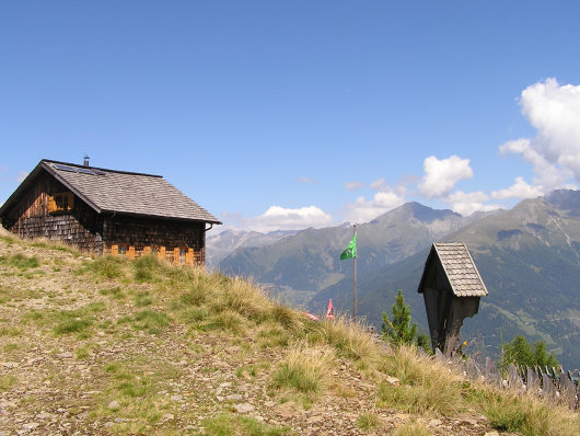 Polinikhütte mit Ankogelgruppe im Hintergrund.